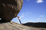 woman holding back giant bolder